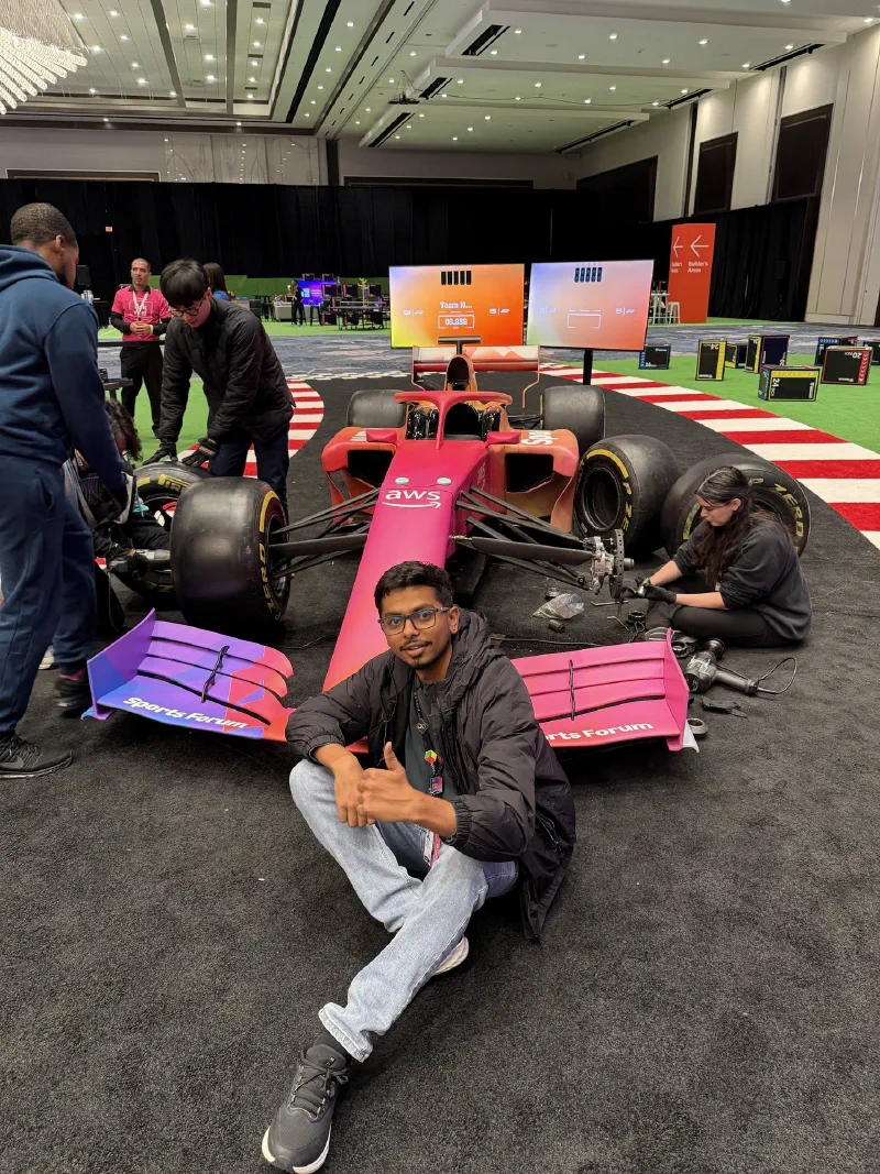 Saugat Tiwari beside an AWS-branded racing car exhibit at re:Invent